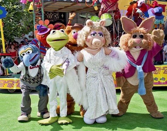 life size muppets on green carpet at disney